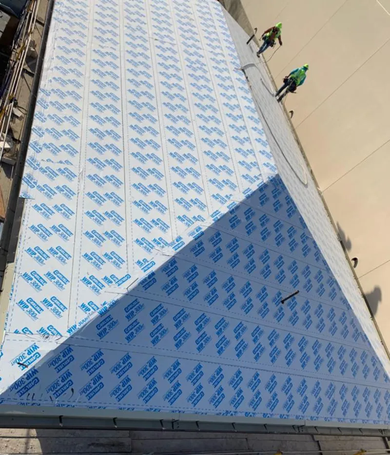 Professional roofers installing underlayment on a metal roof in Pingree Grove